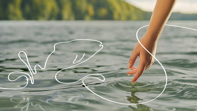 Een hand raakt het water van een meer aan waaruit een geïllustreerde vis springt
